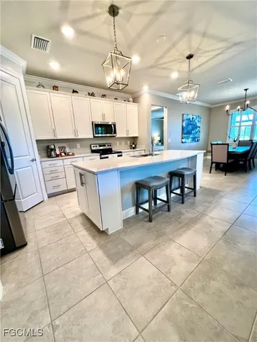 a living room with stainless steel appliances kitchen island granite countertop a sink a counter top space cabinets and stainless steel appliances