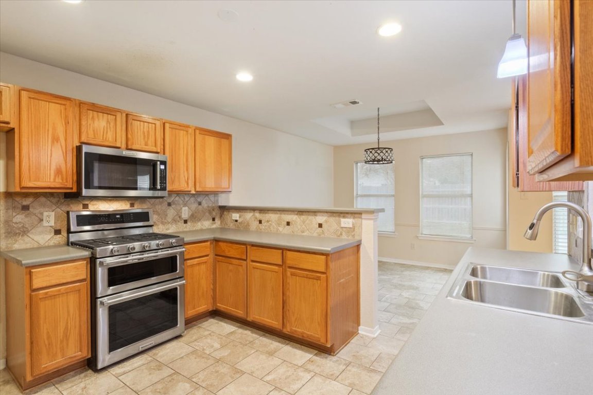 314 Katy Crossing Georgetown, TX 78626 - Photo 14 of 38 a kitchen that has a sink and a stove top oven