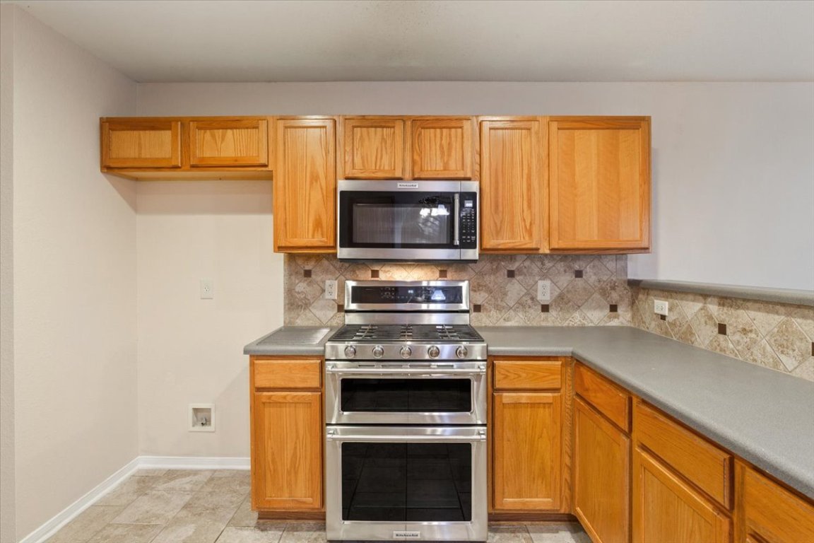 314 Katy Crossing Georgetown, TX 78626 - Photo 15 of 38 a kitchen with stainless steel appliances a stove a microwave sink and cabinets