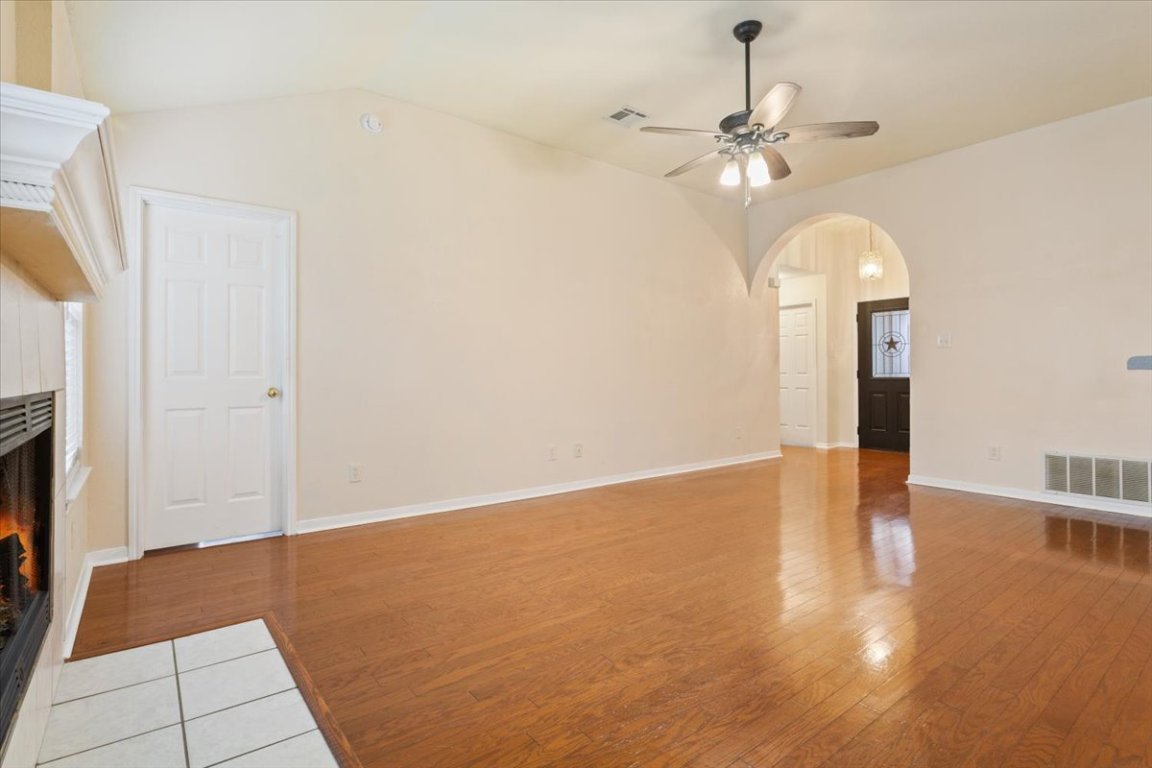 314 Katy Crossing Georgetown, TX 78626 - Photo 7 of 38 a view of an empty room with wooden floor and a ceiling fan
