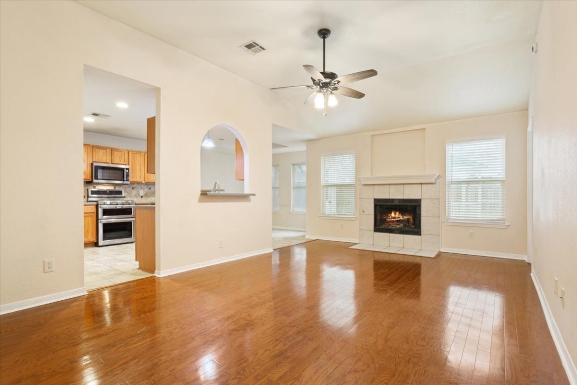 314 Katy Crossing Georgetown, TX 78626 - Photo 10 of 38 a view of a livingroom with a fireplace a ceiling fan and wooden floor