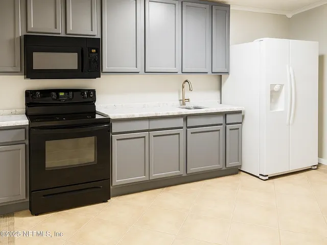 a kitchen with granite countertop a refrigerator stove and a sink