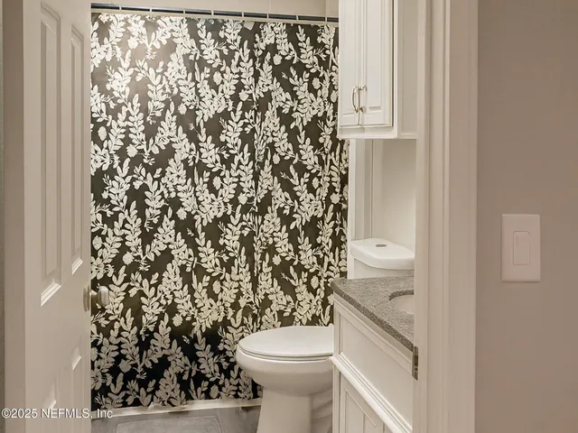 a bathroom with a toilet and a shower curtain
