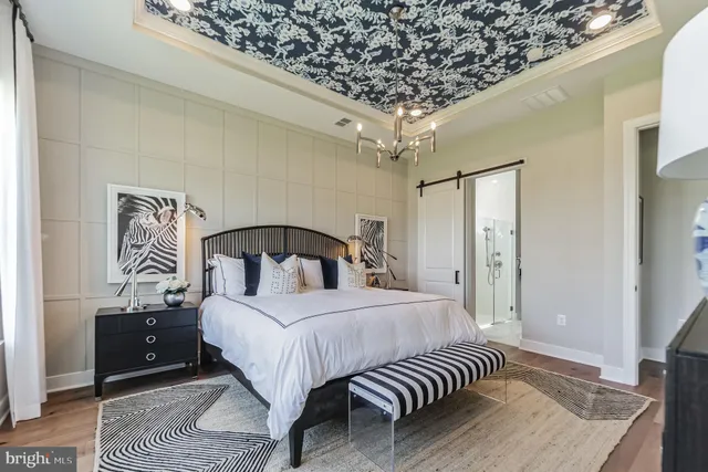 a bedroom with a large bed and a chandelier