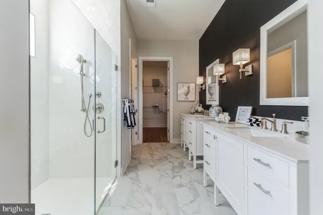 a bathroom with a double vanity sink mirror and shower
