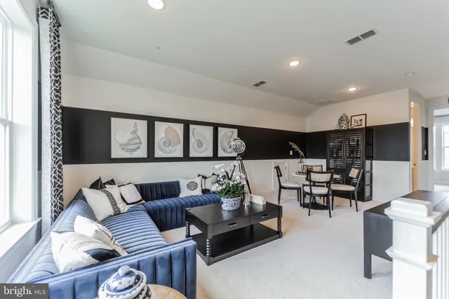 a living room with furniture kitchen view and a large window