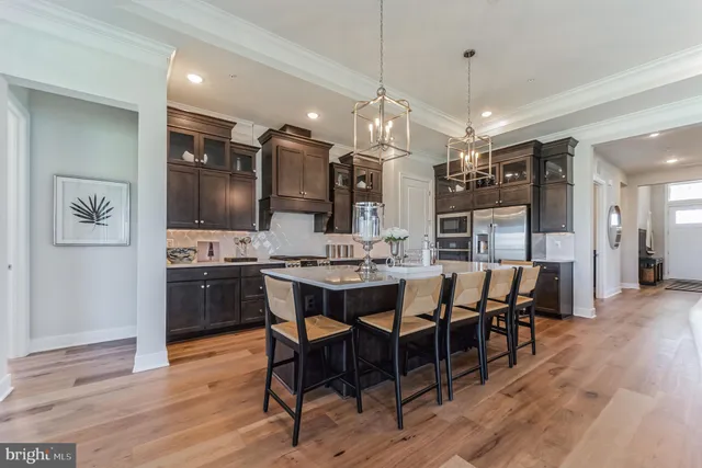 a view of a dining room and livingroom with furniture wooden floor a chandelier