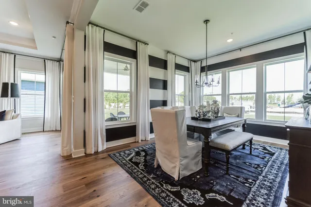 a dining room with furniture a chandelier and wooden floor