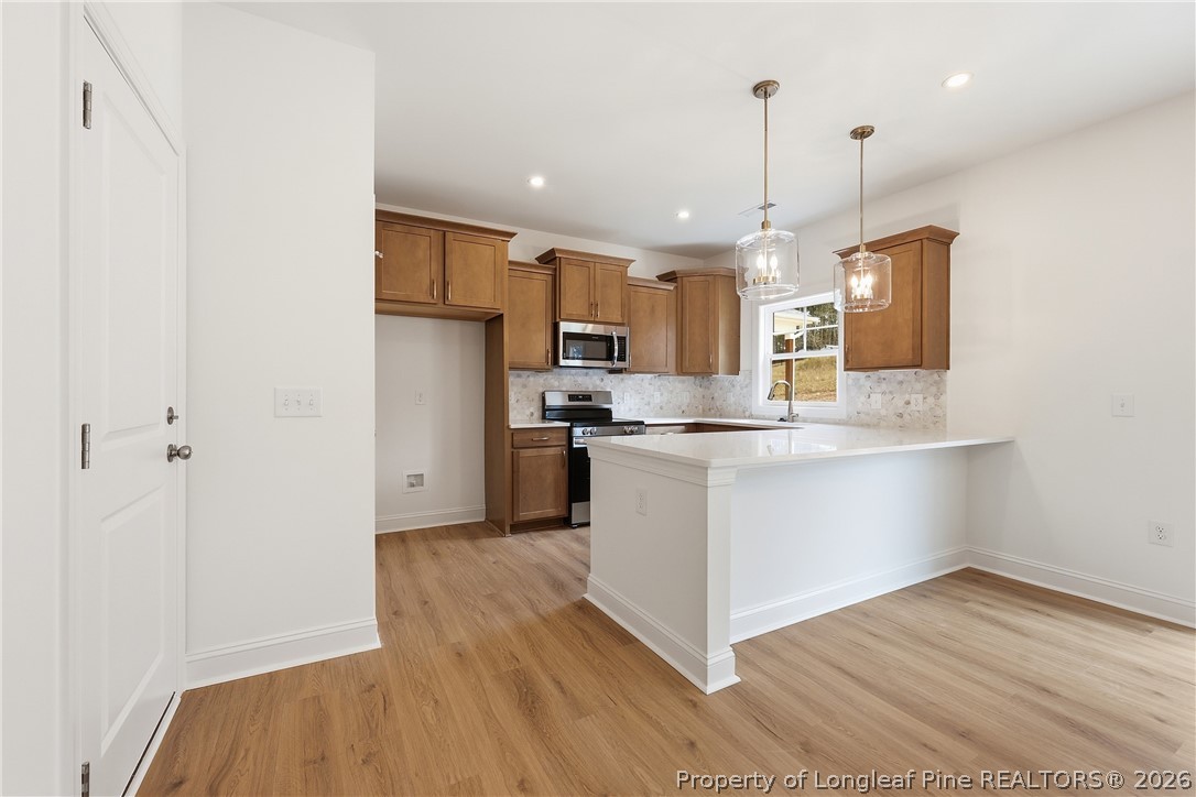 154 Carver Street Carthage, NC 28327 - Photo 15 of 41 a kitchen with stainless steel appliances granite countertop a refrigerator a sink dishwasher a stove and a wooden floor