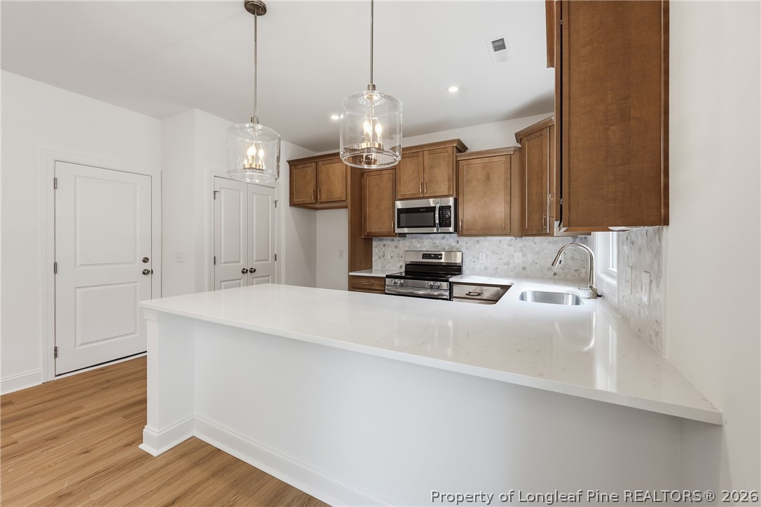 154 Carver Street Carthage, NC 28327 - Photo 16 of 41 a open kitchen with wooden floor and a chandelier