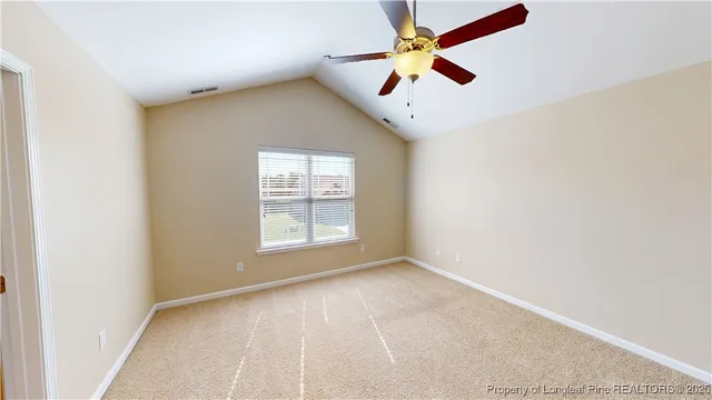 an empty room with ceiling fan and window