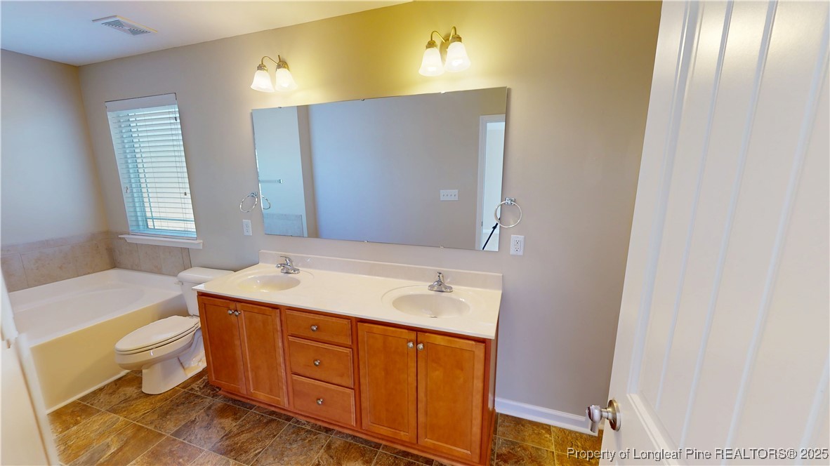 541 Roanoke Drive Raeford, NC 28376 - Photo 17 of 25 a bathroom with a granite countertop sink toilet and mirror