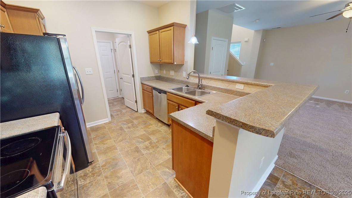541 Roanoke Drive Raeford, NC 28376 - Photo 8 of 25 a kitchen with granite countertop a sink stove and refrigerator