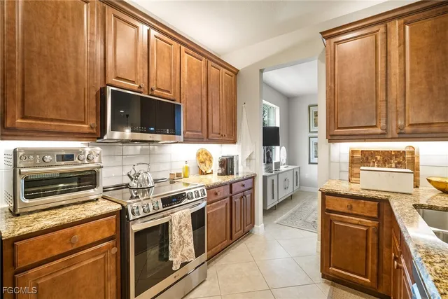 a kitchen with stainless steel appliances granite countertop a stove a sink and a microwave