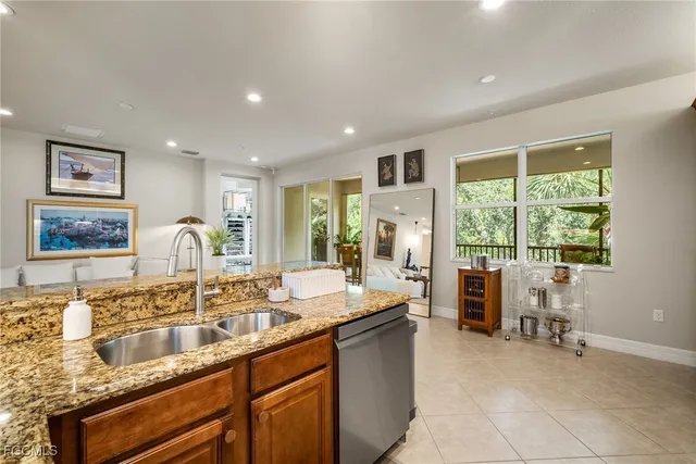 a large kitchen with granite countertop a large counter top a sink a stove and a window