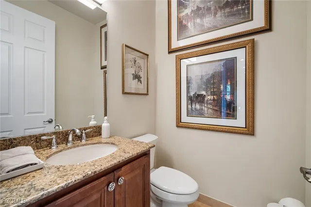 a bathroom with a granite countertop toilet a sink and mirror