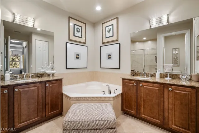a spacious bathroom with a tub sink and mirror