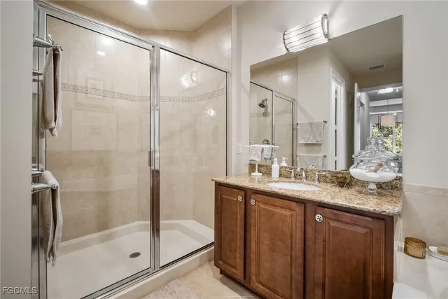 a bathroom with a granite countertop sink mirror and shower