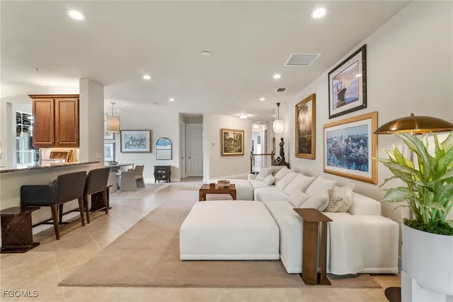 a living room with furniture large window and wooden floor