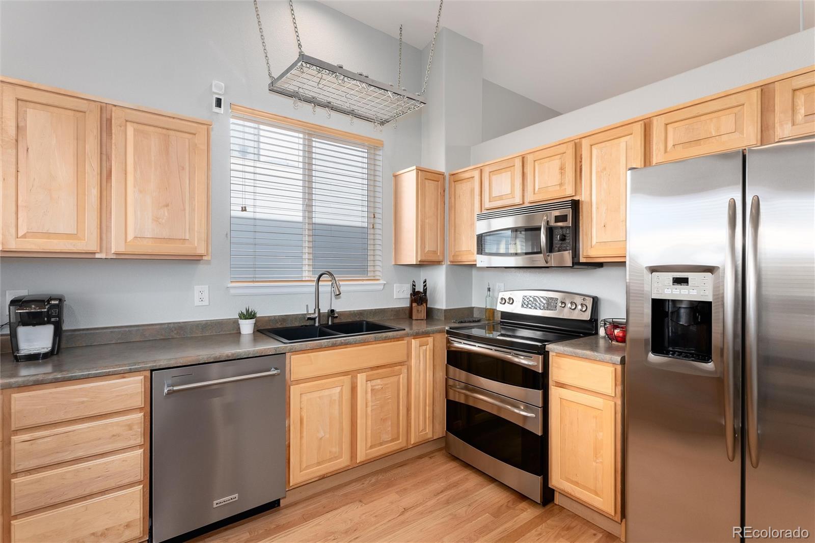 10627 Cherrybrook Circle Highlands Ranch, CO 80126 - Photo 11 of 44 a kitchen with stainless steel appliances granite countertop a stove a sink dishwasher a refrigerator and a microwave oven