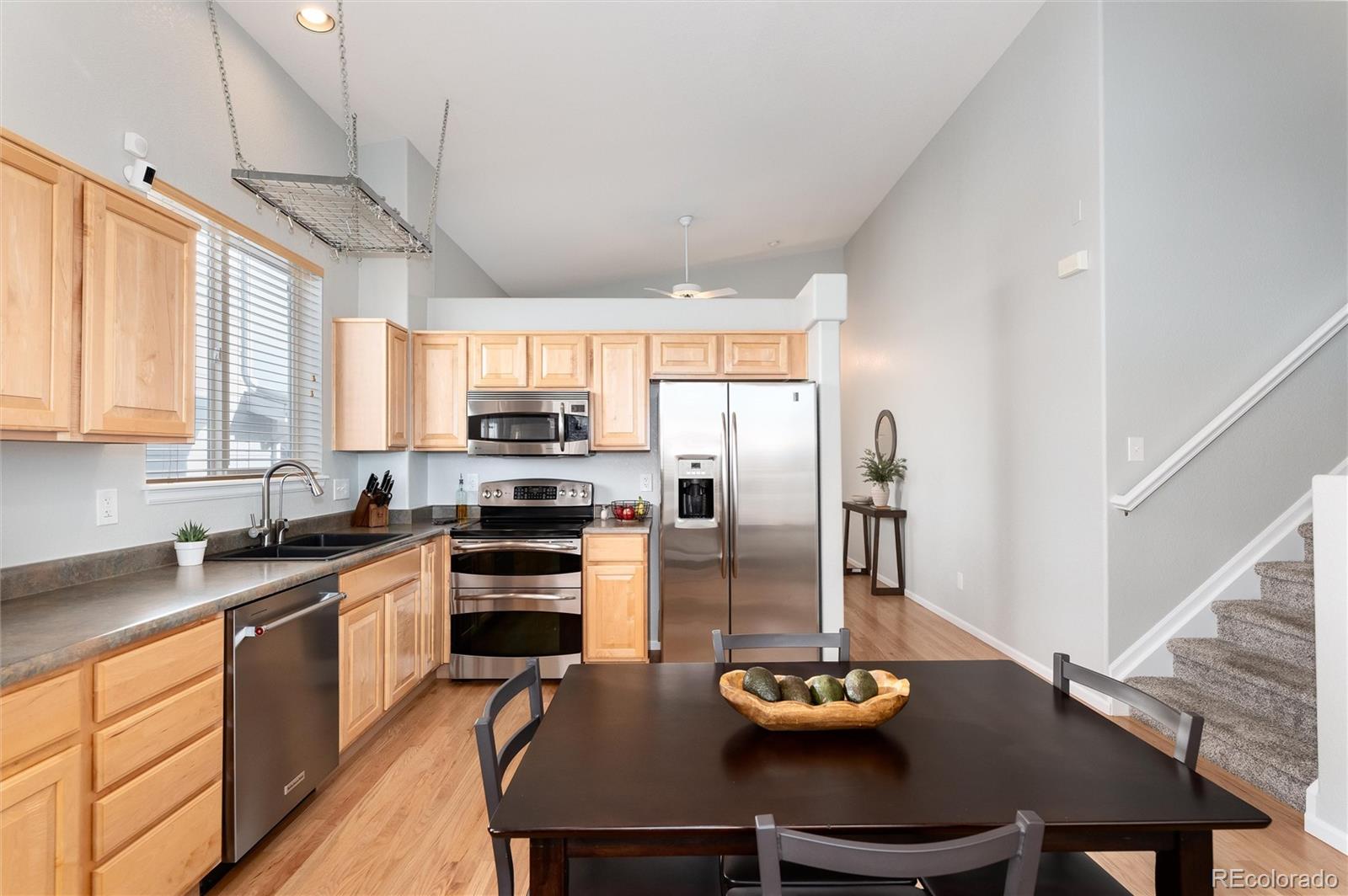 10627 Cherrybrook Circle Highlands Ranch, CO 80126 - Photo 12 of 44 a kitchen with stainless steel appliances kitchen island granite countertop a sink dishwasher a stove a refrigerator with a dining table and chairs