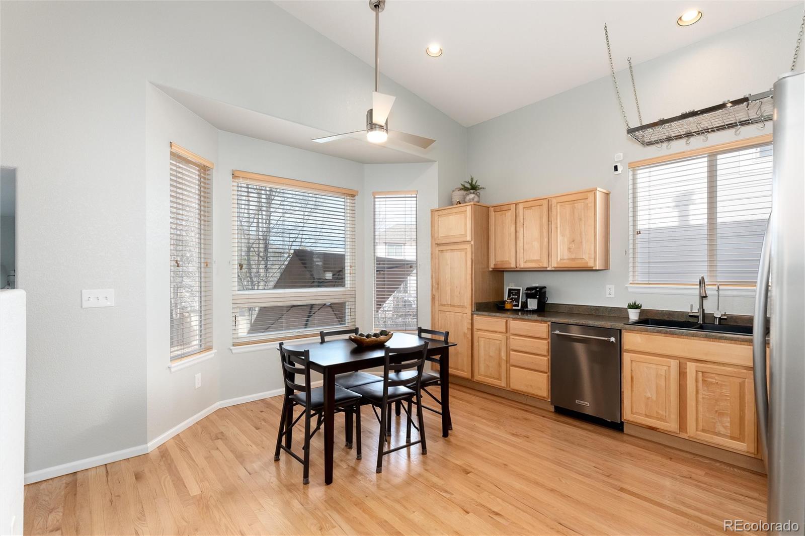 10627 Cherrybrook Circle Highlands Ranch, CO 80126 - Photo 13 of 44 a kitchen with stainless steel appliances granite countertop wooden floor cabinets dining table and chairs