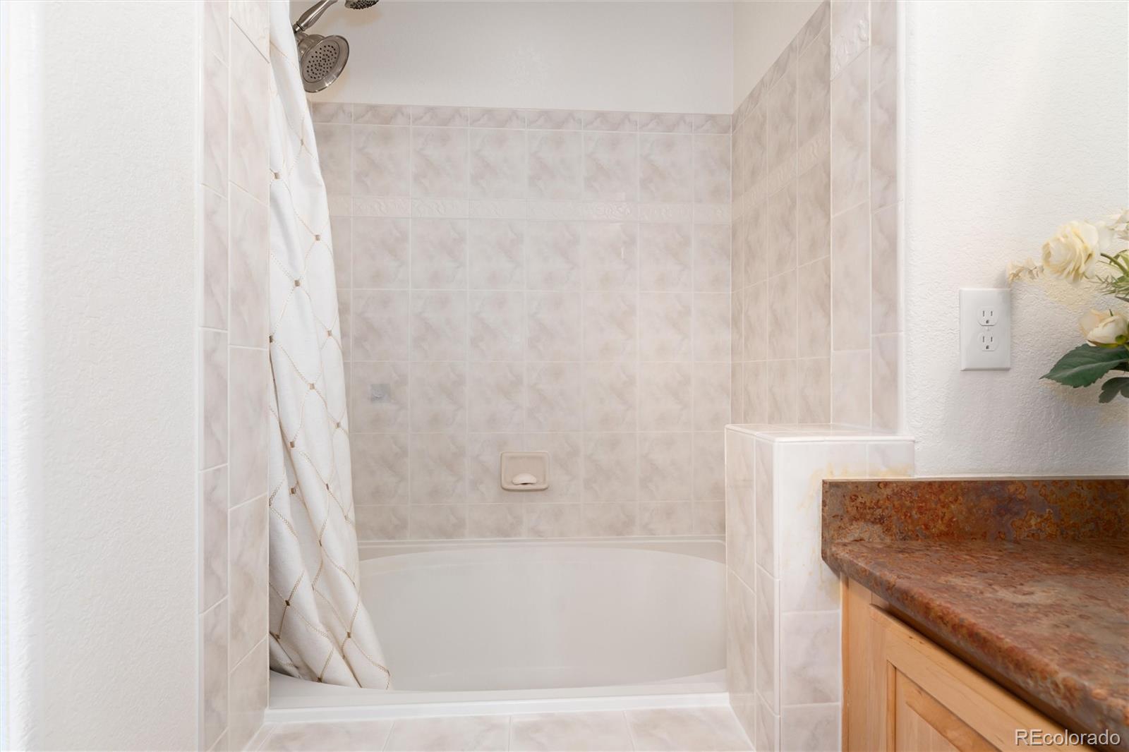 10627 Cherrybrook Circle Highlands Ranch, CO 80126 - Photo 33 of 44 a bathroom with a granite countertop sink and a bathtub