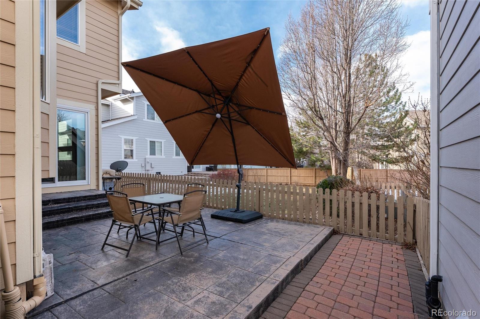 10627 Cherrybrook Circle Highlands Ranch, CO 80126 - Photo 42 of 44 a view of a roof deck with table and chairs under an umbrella