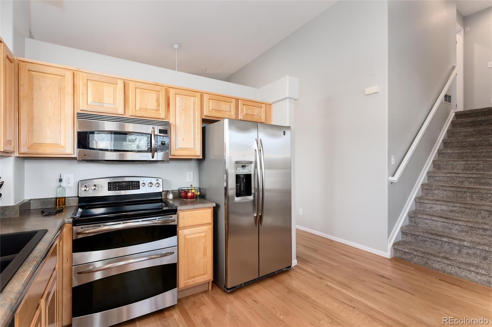 10627 Cherrybrook Circle Highlands Ranch, CO 80126 - Photo 10 of 44 a kitchen with granite countertop a refrigerator stove and microwave
