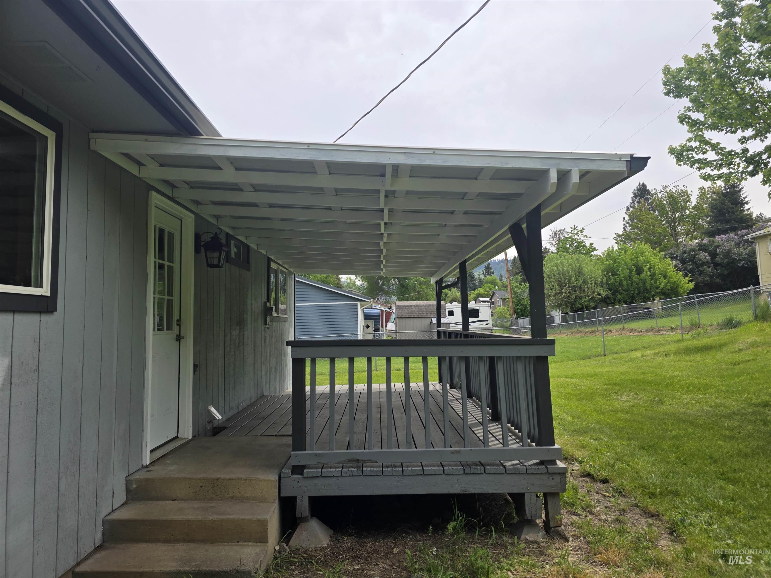 310 Fir Road Kamiah, ID 83536 - Photo 4 of 32 Covered deck with dark wood railing and slatted flooring