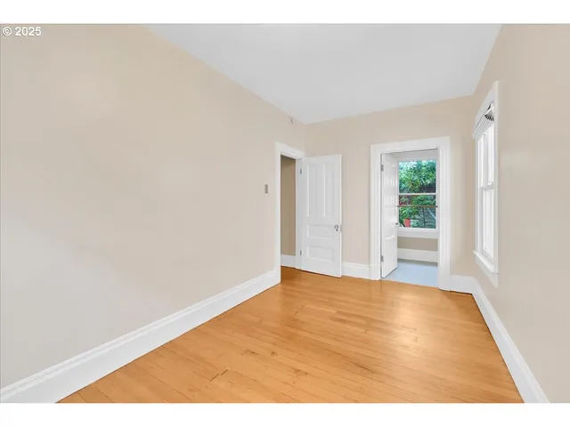 a view of empty room with wooden floor
