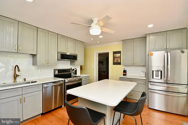 a kitchen with a refrigerator a stove microwave cabinets and a sink