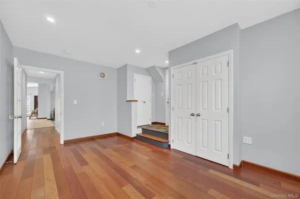 a view of a hallway with wooden floor and closet