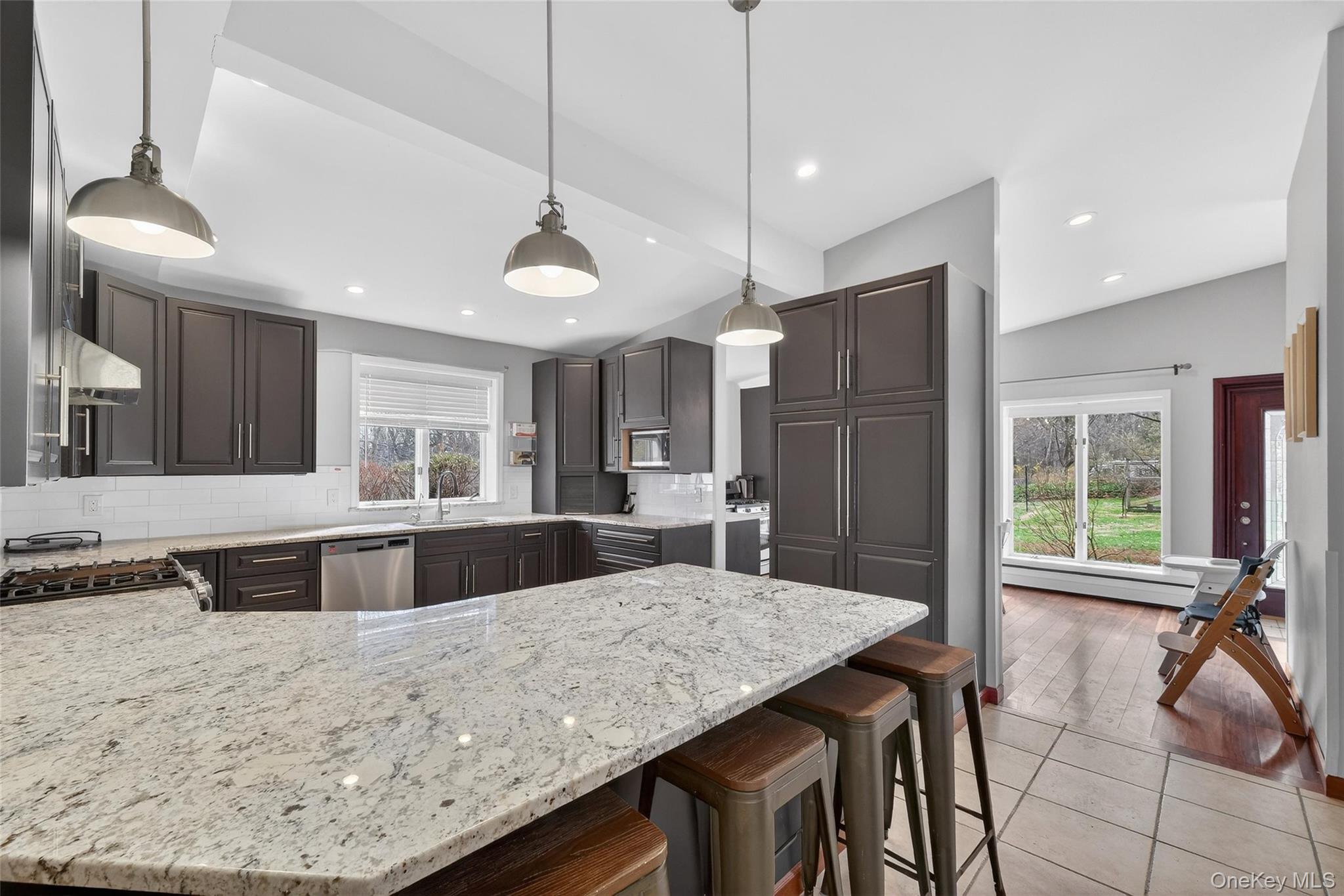 155 Roselawn Road Highland Mills, NY 10930 - Photo 7 of 40 a kitchen with stainless steel appliances kitchen island granite countertop a table chairs and a refrigerator