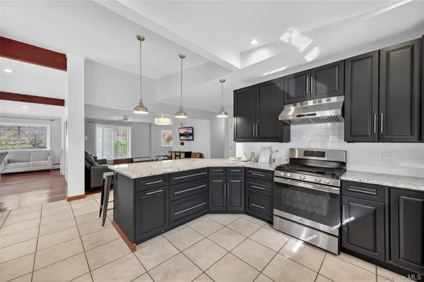 a kitchen with stainless steel appliances granite countertop a stove a sink and a refrigerator