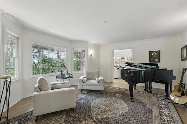 a living room with furniture a piano and a window