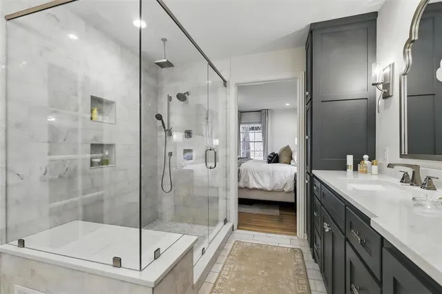 a en suite bathroom with a shower sink and mirror