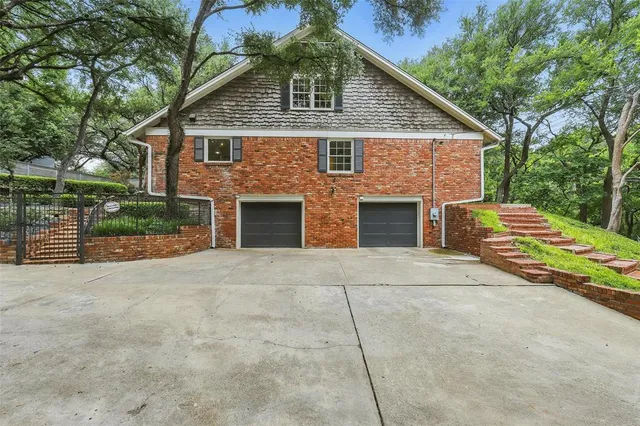 a front view of house with yard and trees in the background