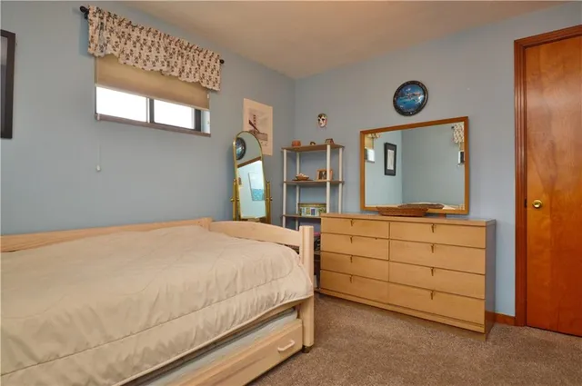 a bedroom with a bed and a mirror on dresser