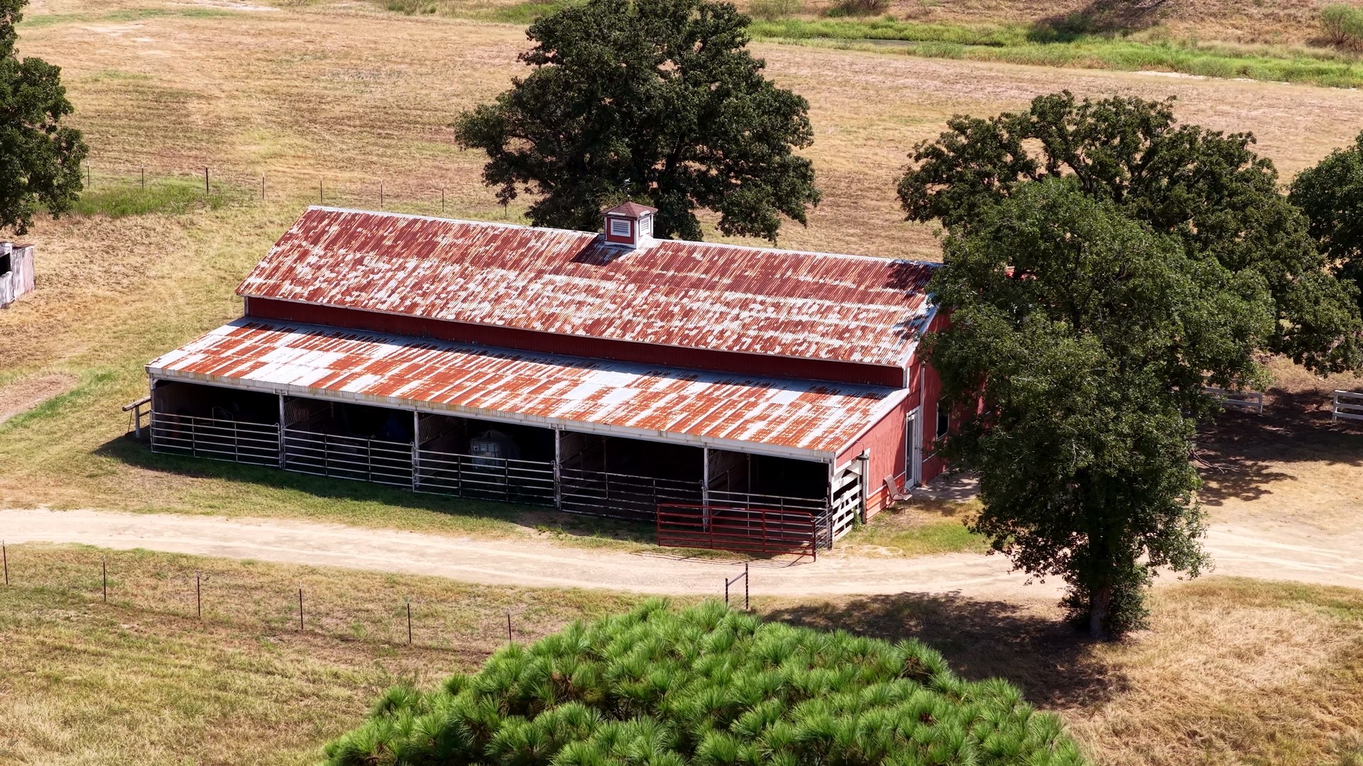 218 Little Ranch Road Red Rock, TX 78662 - Photo 33 of 33 A classic rustic barn sits nestled among mature trees on expansive countryside acreage.