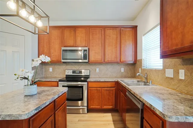 a kitchen with stainless steel appliances granite countertop a sink stove and microwave