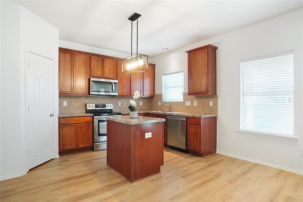 3752 Jade Street Fort Worth, TX 76244 - Photo 5 of 34 a kitchen with stainless steel appliances granite countertop a stove top oven a sink dishwasher a refrigerator and a microwave