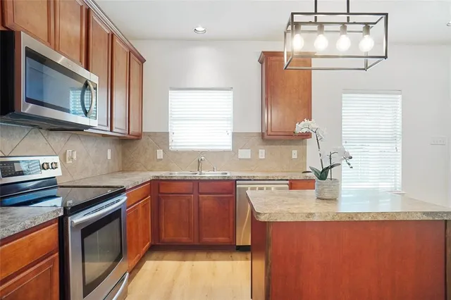 a kitchen with stainless steel appliances granite countertop a sink stove and cabinets