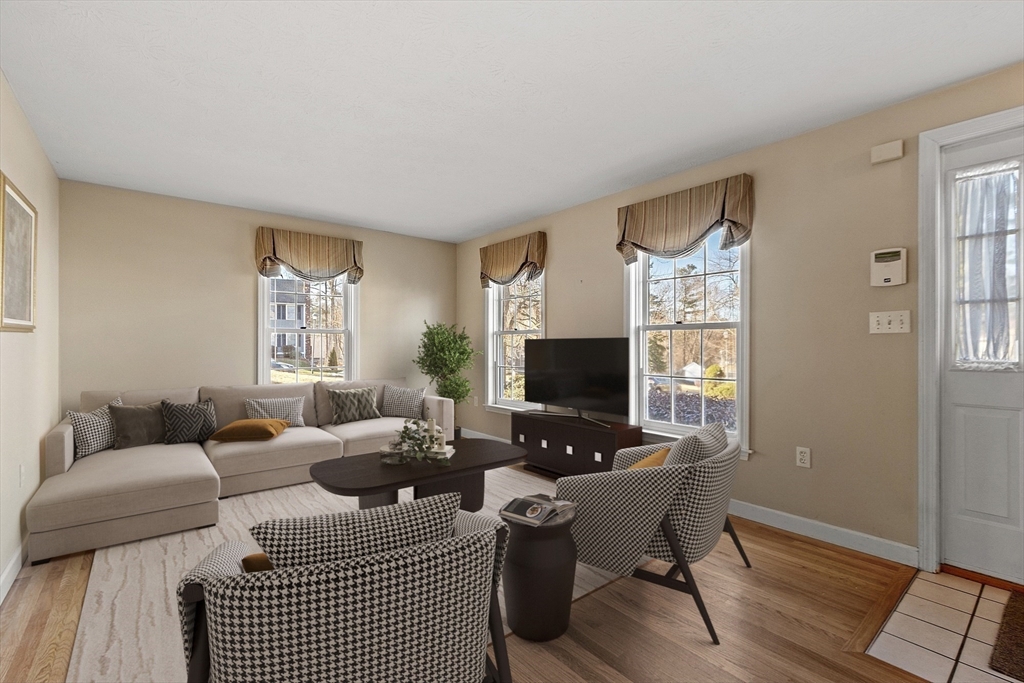 92 Stonegate Road, Unit 92 Chelmsford, MA 01824 - Photo 4 of 32 a living room with furniture a wooden floor and a window