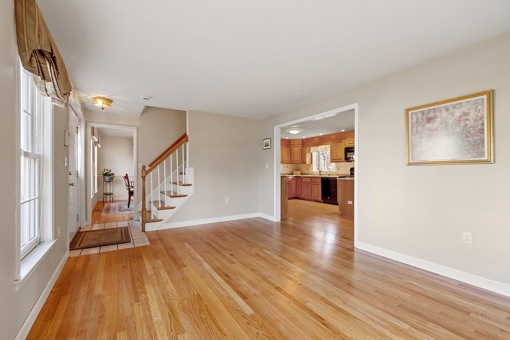 92 Stonegate Road, Unit 92 Chelmsford, MA 01824 - Photo 5 of 32 a view of an empty room with wooden floor and a window