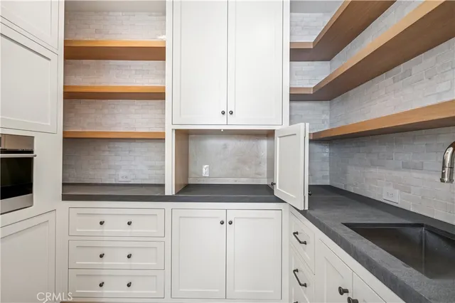 a view of kitchen with white cabinets and a sink