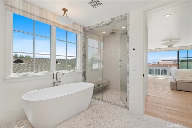 a bathroom with a tub a sink and a large window