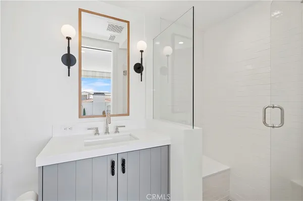 a bathroom with a sink a mirror a vanity and shower