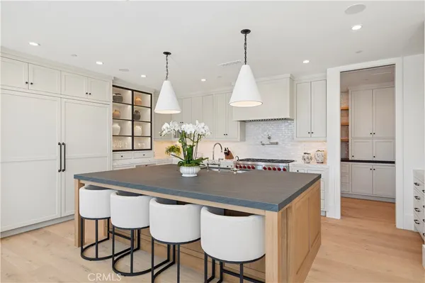 a kitchen with stainless steel appliances granite countertop a sink a stove a refrigerator and island