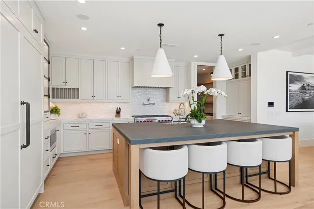 a kitchen with stainless steel appliances granite countertop a kitchen island a stove a table and chairs in it